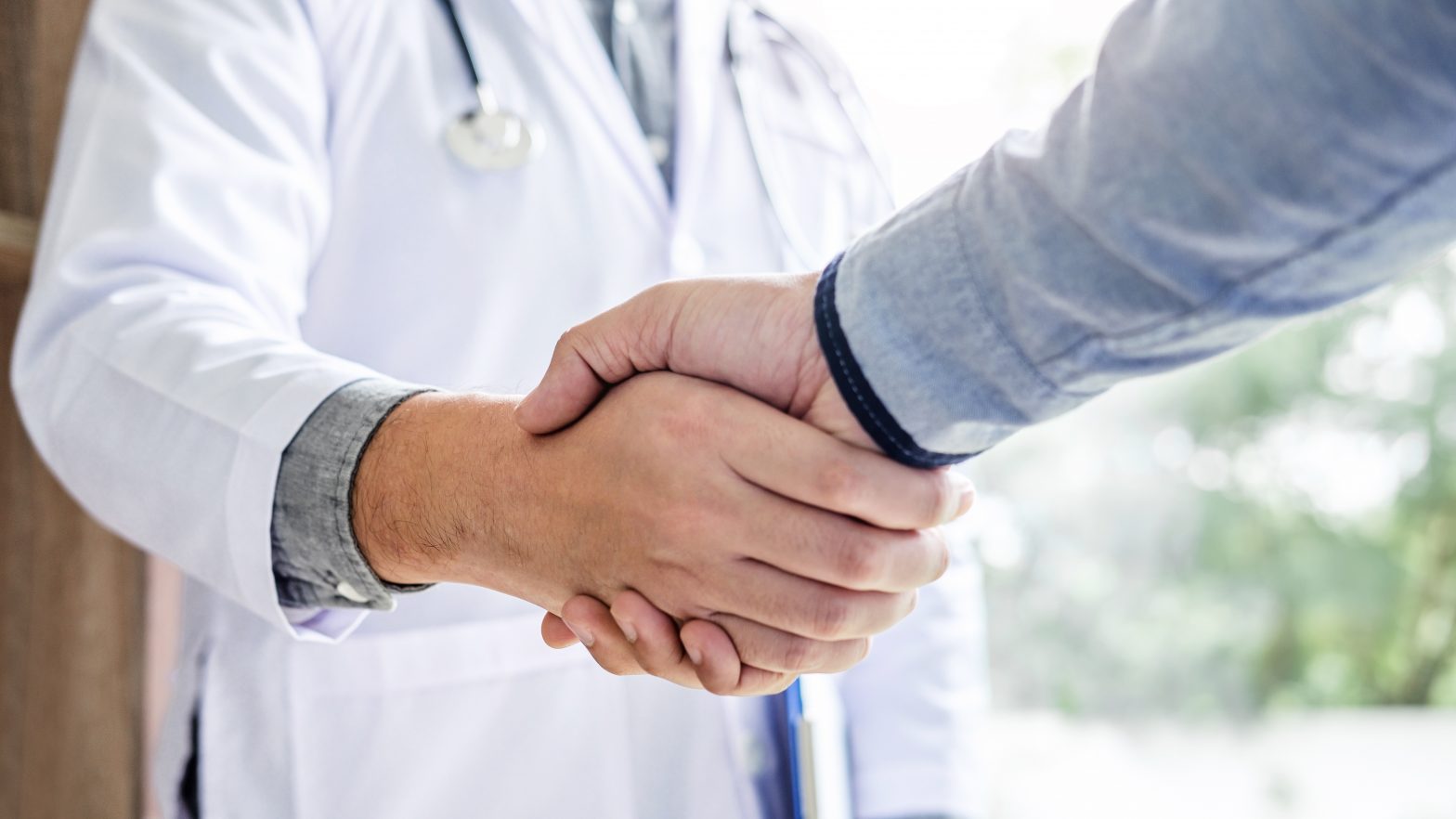 Doctor shaking hands with field reimbursement manager